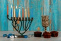 Menora with nine burning candles, dreidel and cupcakes. Jewish holiday Hanukkah