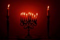 A menorah filled with lit candles and flanked by two single candles for the Jewish holiday, Hanukkah.