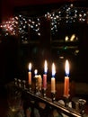 Menorah with five burning candles in darkened dining room