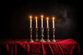 menorah with glowing candle flames against a dark cloth background