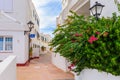 Street with traditional Spanish houses decorated with flowers in Binibeca Nou village. Menorca