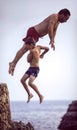 Menorca, Spain - September 8: Man and kid jumping from cliff into the sea, in September 8, 2014 in Menorca, Spain Royalty Free Stock Photo