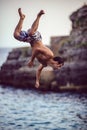 Menorca, Spain - September 8: Young man jumping from cliff into the sea, in September 8, 2014 in Menorca, Spain Royalty Free Stock Photo