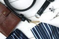 Mens accessories - wallet, belt, cufflinks, watch, tie clip, handkerchief on a white wooden background