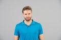 Mens beauty, fashion and style. Man in blue tshirt on grey background. Guy with bearded unshaven face. Macho with blond hair and s Royalty Free Stock Photo