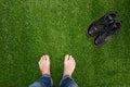 Mens feet resting on green grass with standing boots