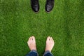 Mens feet resting on green grass with standing opposite boots Royalty Free Stock Photo