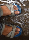 Mens foot wearing sandals under water.