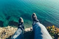 Mens legs in sneakers in background of picturesque sea landscapehiking travel relaxing concept