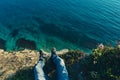 Mens legs in sneakers in background of picturesque sea landscapehiking travel relaxing concept