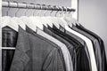 Mens shirts, suit hanging on rack. Hangers with jackets on them in boutique. Suits for men hanging on the rack. Black Royalty Free Stock Photo