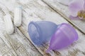 Menstrual cup on an old wooden table withe white paint