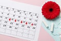 Menstrual cycle calendar on a pink background. pills and tampons, pads. Ovulation concept. Royalty Free Stock Photo