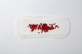 Menstrual pad with red sequins on white background, top view Royalty Free Stock Photo