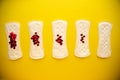Menstrual pads with bright red glitter on yellow colored background. Woman periods cycle, menstruation frequency