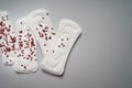 Menstrual pads with small red hearts on grey background