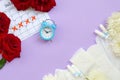 Menstrual pads and tampons on menstruation period calendar with blue alarm clock and red rose flowers Royalty Free Stock Photo