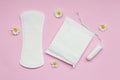 feminine hygiene and protection products, sanitary pads, tampon and chamomile flowers on pastel pink background, top view, flat la Royalty Free Stock Photo