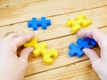 adult person plays with yellow and blue puzzzles