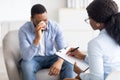 Mental health care. Professional psychotherapist having session with depressed crying young black man at clinic Royalty Free Stock Photo