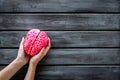 Mental health concept with brain in hands on wooden background top view space for text