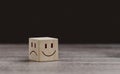 Mental health and emotional state concept, Smile face in bright side and sad face in dark side on wooden block cube for positive Royalty Free Stock Photo