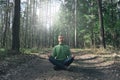 Mental health, feeling nature, mindfulness concept. Young bearded man practicing yoga outdoor, sitting in pose of lotus with eyes