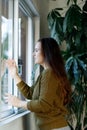 Mental health  stress  depression during quarantine  covid 19 coronavirus lockdown  lonely young woman looking window  negative Royalty Free Stock Photo