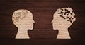 Mental health symbol. Human head silhouette with a puzzle cut out from wooden background