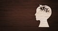 Mental health symbol. Human head silhouette with a puzzle cut out from wooden background Royalty Free Stock Photo