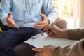 Mental illness. Female psychologists is writing male patient information to a clipboard