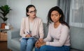 Mental medical support. Sad young european lady doctor in glasses calms black woman patient in office