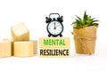 Mental resilience symbol. Concept word Mental resilience on wooden blocks. Beautiful white table white background. Black alarm