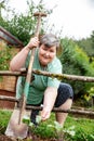 Mentally diasabled or handicapped woman is kneeing behind a wooden fence in the garden