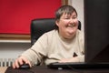 Mentally disabled woman sitting at the computer, Education and L Royalty Free Stock Photo