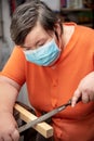 Mentally disabled woman working at a sheltered workshop with surgical mask covid-19