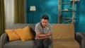 A mentally unstable man is sitting on a sofa in the living room. Concept for depression, suicide, stress, mental illness Royalty Free Stock Photo