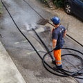 Sewer cleaning and worker with water and hose in pipe