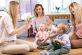 Mentor and 1 years old babies play with educational toys in kindergarten or daycare centre Royalty Free Stock Photo