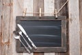 Menu blackboard with fork, spoon and knife on wood background Royalty Free Stock Photo