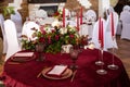 The menu card lies on a red napkin on plates, a gilt fork and knife on the sides of the plate, a glass of brown glass, flower Royalty Free Stock Photo