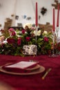 The menu card lies on a red napkin on plates, a gilt fork and knife on the sides of the plate, a glass of brown glass, flower Royalty Free Stock Photo