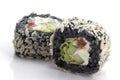 Two sushi with black rice closeup.Sushi rolls with rice and fish on a white plate with reflec Royalty Free Stock Photo