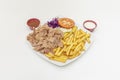 Menu lamb kebab plate with fried potatoes, chopped meat, purple cabbage, iceberg lettuce and tomato slices, Royalty Free Stock Photo