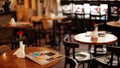 Menu lefted on vintage wooden table decorated with red fresh rose in an empty restaurant.