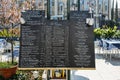 Menu and prices in English and Italian on a billboard on the streets of Lido