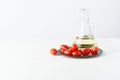 Menu, recipe, mock up, banner. Food background. Glass jug for olive oil, tomatoes on plate, light white background, white wooden