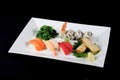 Menu of sushi and roll fish with vegetables on white plate