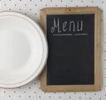 Menu title written with chalk on blackboard lying on tablecloth polka dot. Copy space for your text. Top view