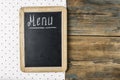 Menu title written with chalk on blackboard lying on tablecloth polka dot. Copy space for your text. Top view